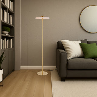 Amity LED floor lamp with opal glass diffuser in brass finish positioned beside a sofa in a modern living room.