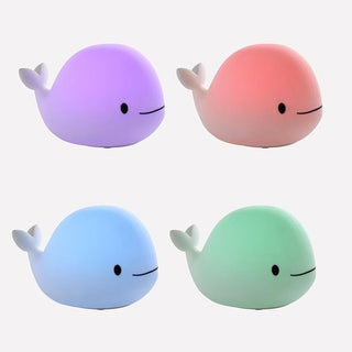 Four colorful whale-shaped night lights on a white background