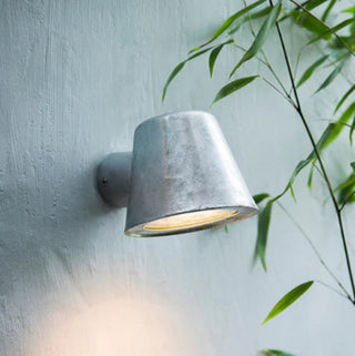 Skopa wall light installed on outdoor wall beside plants