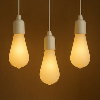 Three illuminated light bulbs hanging against a dark brown background