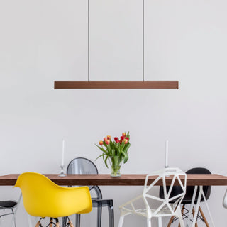 Modern dining area with a wooden table, colorful chairs, and a hanging light fixture.