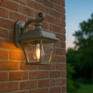 Outdoor wall light fixture on a brick wall with a blurred natural background