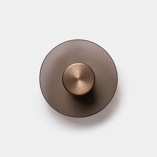 Close-up of Eclipse 150 Wall Lamp showing hand and brushed bronze detail