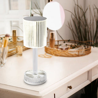 Modern table lamp on a white surface with decorative items in the background