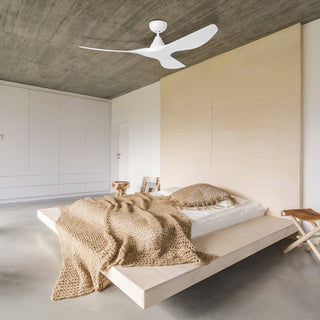 Modern bedroom with a bed, ceiling fan, and minimal decor.