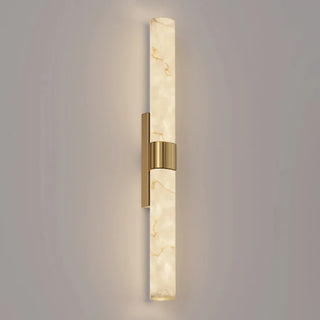 CLA LECHA large wall light illuminated, showing faux marble veining and satin brass detailing.