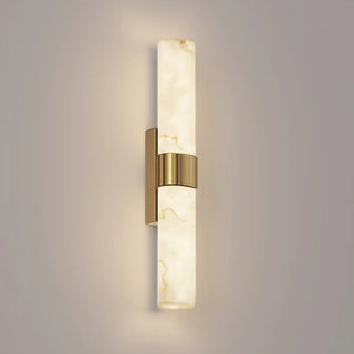 CLA Flecha medium wall light illuminated, showing faux marble veining and satin brass detailing