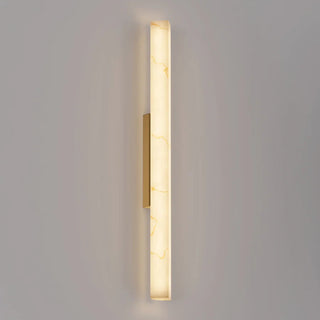Flecha Angled large wall light illuminated, featuring a faux marble diffuser with veining and brass highlights.