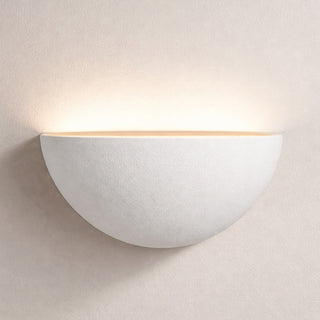 White wall-mounted light fixture on a beige wall