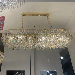Crystal chandeliers hanging from a ceiling in a showroom setting.