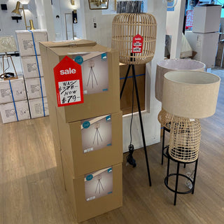 Cardboard boxes with sale tags on a wooden floor, surrounded by decorative lamps.