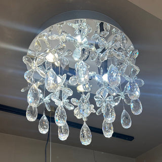 Crystal chandelier hanging from a ceiling with a neutral background