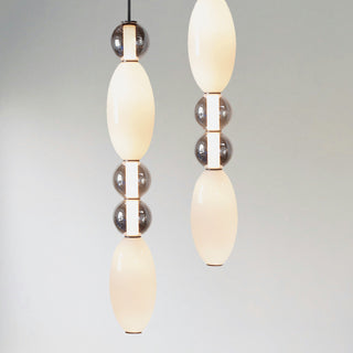 Close-up of Ideal Lux Lumiere 3 pendant showing illuminated white diffuser and grey glass detailing