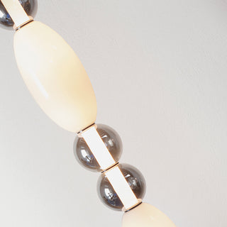 Close-up of Ideal Lux Lumiere 3 pendant showing illuminated white diffuser and grey glass detailing