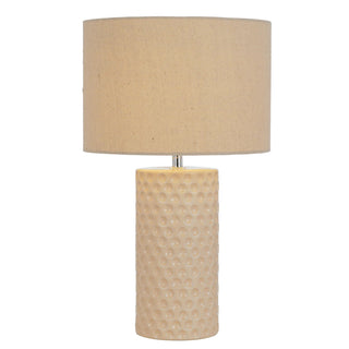 Beige table lamp with textured base on a white background
