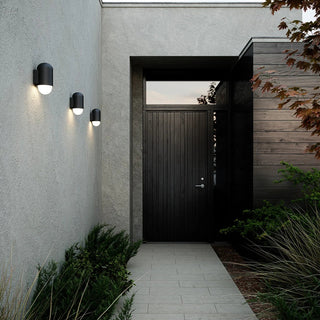 Modern exterior of a house with a dark door and wall-mounted lights.