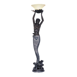 Mermaid floor lamp holding a bowl shade above her head, with a detailed scaled tail and wave-inspired base