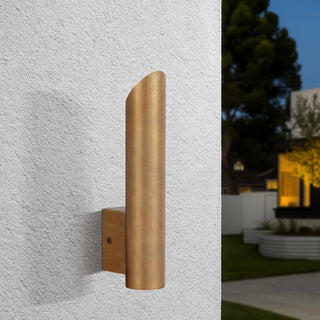Penros 1 Light in Natural Brass mounted on textured exterior wall, emitting warm light.