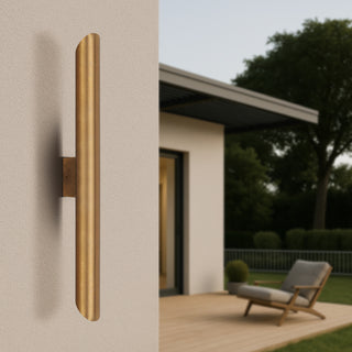 Penros 2 Light installed on exterior wall in Natural Brass, casting warm up/down light.