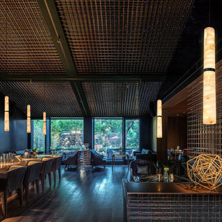 Modern restaurant interior with dark wood flooring, ceiling, and walls.
