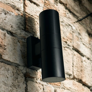 Black outdoor wall light fixture on a brick wall