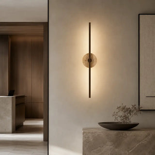 Rimini travertine wall light creating warm ambient light above a console table