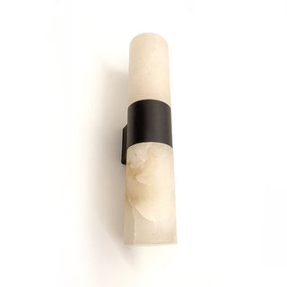 Wall sconce with beige stone finish and black metal accent on a white background