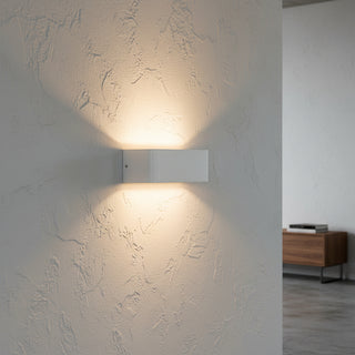 A modern white rectangular wall-mounted light fixture with a smooth matte finish and a recessed diffuser, shown against a plain white background.