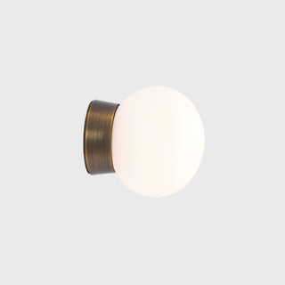 Wall-mounted light fixture with a brass finish on a white background
