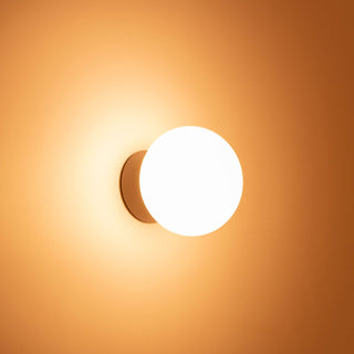 Round wall light fixture on a warm orange background