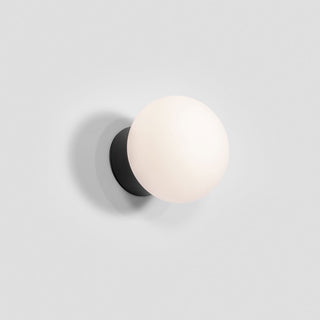 Wall-mounted light fixture with a white spherical shade and black base on a gray background
