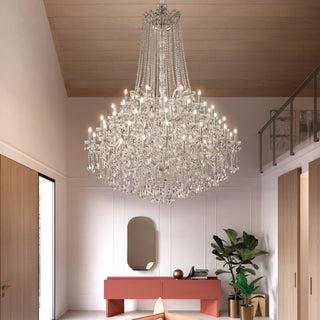 Chandelier hanging in a modern interior setting with a red console table and plants.