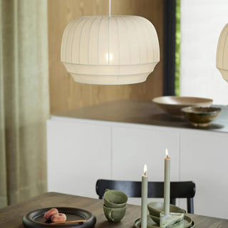 Dining room with a pendant lamp, candles, and bowls on a table.