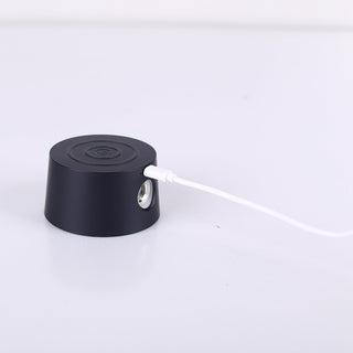Black cylindrical object with a white cable on a light gray background
