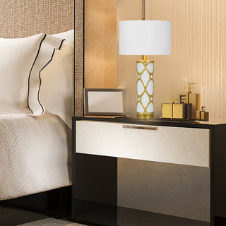 Modern bedroom with a nightstand, lamp, and decorative items.
