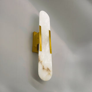 Wall-mounted light fixture with marble-like design and gold accents on a gray wall.