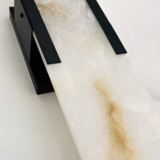Marble wall sconce with black metal brackets on a white background