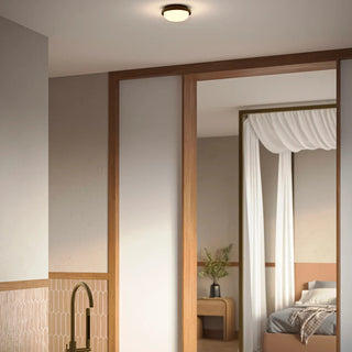 Bode Round Wall/Ceiling Light by Lighting Republic ceiling mounted in bathroom with warm ambient LED glow