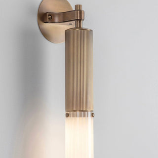 Wall-mounted light fixture with brass finish on a white background