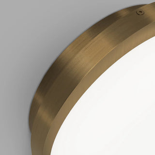 Bode Round Wall/Ceiling Light by Lighting Republic creating soft warm glow above lounge chair in minimalist interior