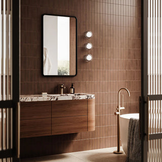 Three Orb Sur Ribbed Wall Lights installed beside a modern bathroom mirror with warm tiled wall finish
